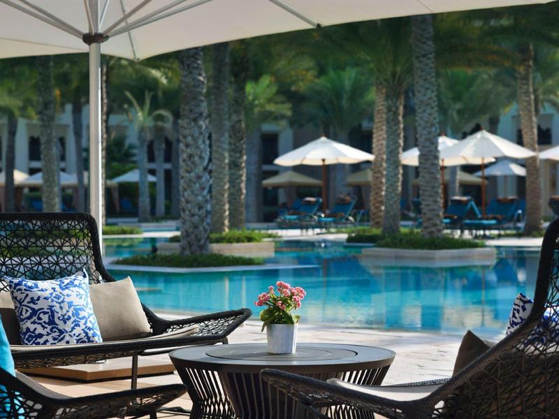 Gezellige zithoek met tafel en bloem bij het zwembad in een tropisch hotel.