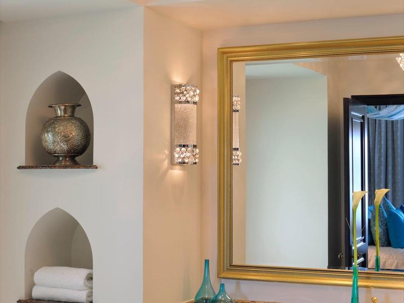 Elegante hotelbadkamer met grote spiegel, decor en handdoeken in nissen.