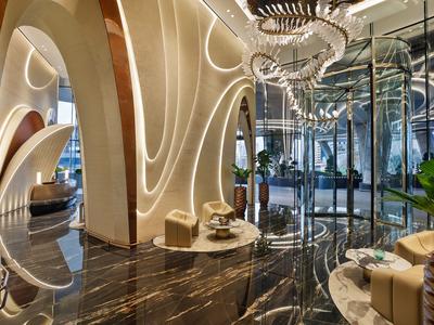 Moderne hotel lobby met gebogen muren, LED-lichtaccenten en gepolijste marmeren vloer.