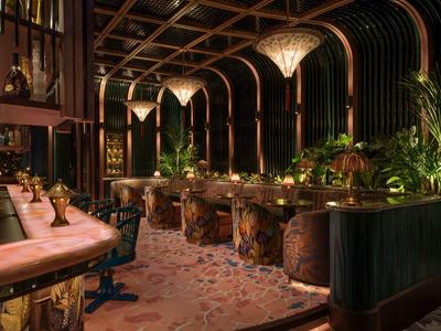 Elegante hotelbar met donker hout, warme verlichting en plantenaccenten