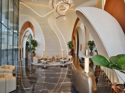 Elegante hotel lobby met gewelfde plafond, comfortabele zitplaatsen en glanzende marmeren vloer.