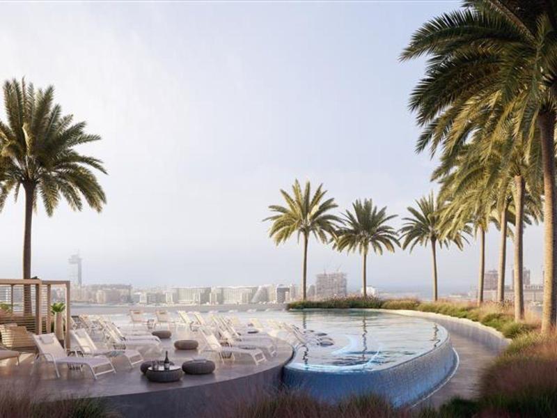 Luxe zwembad met palmbomen en uitzicht op de stad bij zonsopgang.