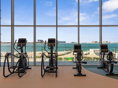 Fitnessstudio mit Blick auf das Meer durch große Fenster