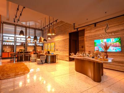 Moderner Hotel-Lobbybereich mit Holzwänden, Beleuchtung und Sitzbereich.