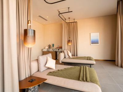 Moderner Ruheraum mit Liegen, grünen Decken und sanfter Beleuchtung in einem Hotel.