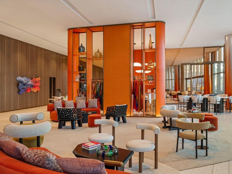 Moderní hotelová lounge s oranžovými příčkami a pohodlným posezením.