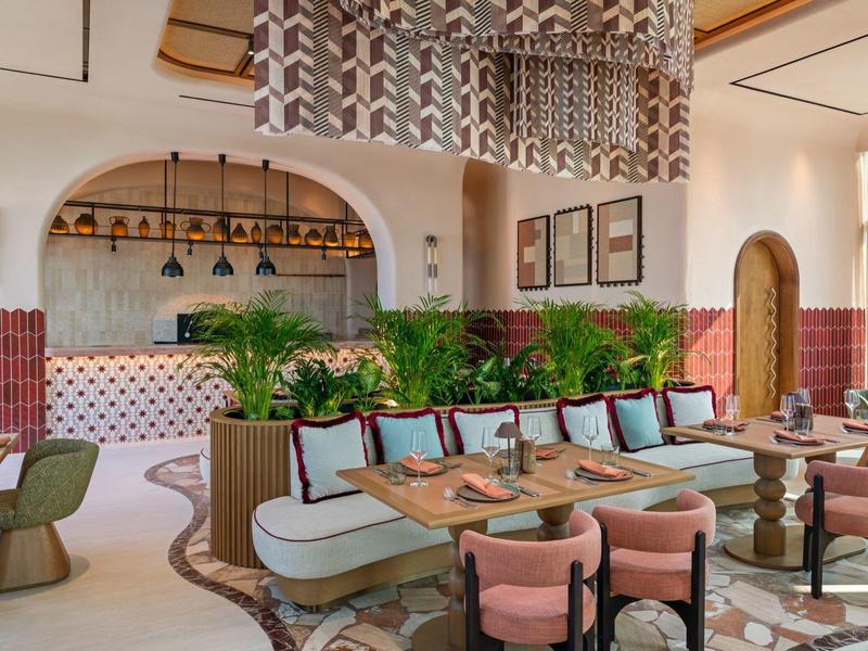 Moderní hotelový bar s elegantními sedadly, rostlinami a dekorativním lustr