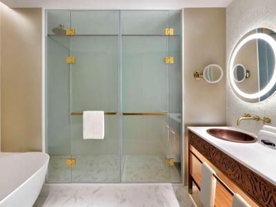 Modernes Badezimmer mit begehbarer Dusche, Badewanne und Doppelwaschbecken mit beleuchtetem Spiegel.