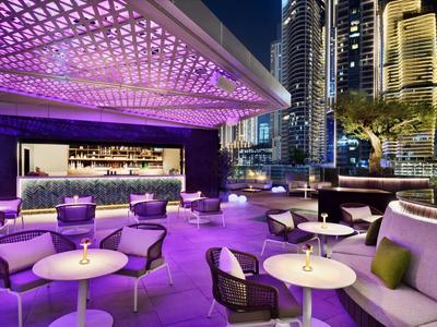 Moderne Dachterrasse mit Lounge-Möbeln und Stadtlichtern bei Nacht