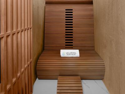 Moderner Wellnessbereich mit Holzliege und einem Handtuch, ruhige Atmosphäre.