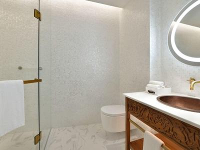 Modernes Badezimmer mit Glasdusche, WC und Holzwaschtisch mit rundem Spiegel.