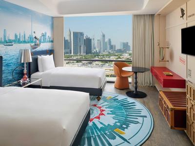 Helles Hotelzimmer mit zwei Betten, Stadtblick und modernem Interieur.