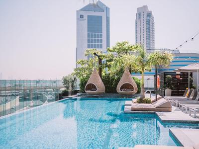 Dachpool mit modernen Liegestühlen und Stadtblick bei klarem Himmel