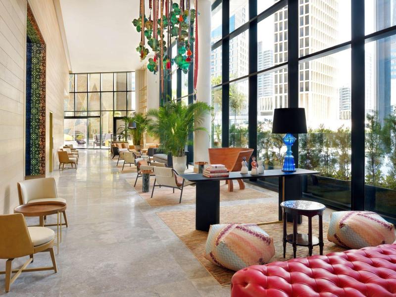 Heller, moderner Loungebereich mit großen Fenstern, verschiedenen Sitzgelegenheiten und Pflanzen.