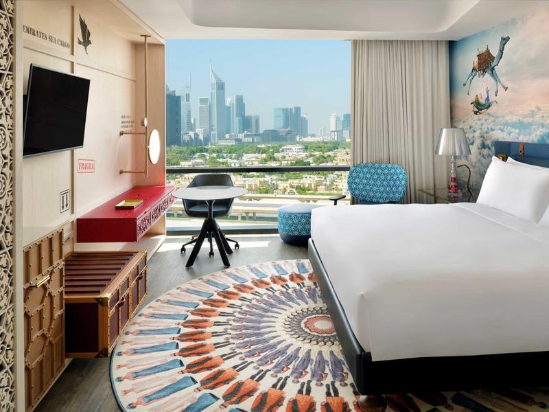 Modernes Hotelzimmer mit großem Bett, Teppich und Fenster mit Stadtblick