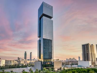 Moderní mrakodrap za soumraku ve městě s rozlehlou oblohou.