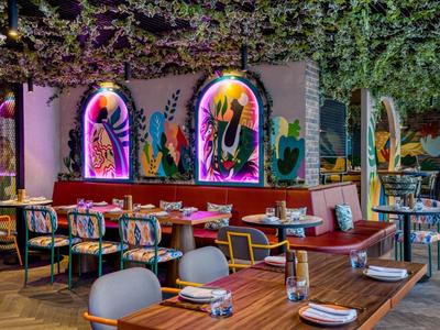 Moderní restaurace s barevnými nástěnnými dekoracemi a útulnými posezeními