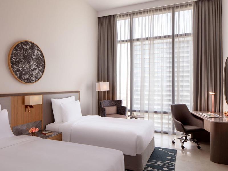 Moderní hotelový pokoj se dvěma jednolůžky, velkým oknem a stylovým zařízením