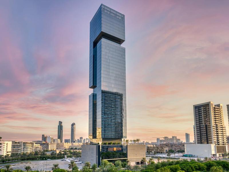 Moderní mrakodrap za soumraku ve městě s rozlehlou oblohou.