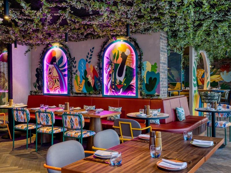 Moderní restaurace s barevnými nástěnnými dekoracemi a útulnými posezeními