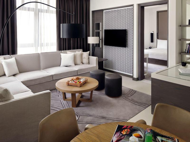 Modern living room with large sofa, coffee table, and flat-screen TV