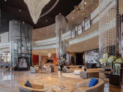 Lujoso vestíbulo de hotel con áreas de asientos elegantes y columnas decorativas.