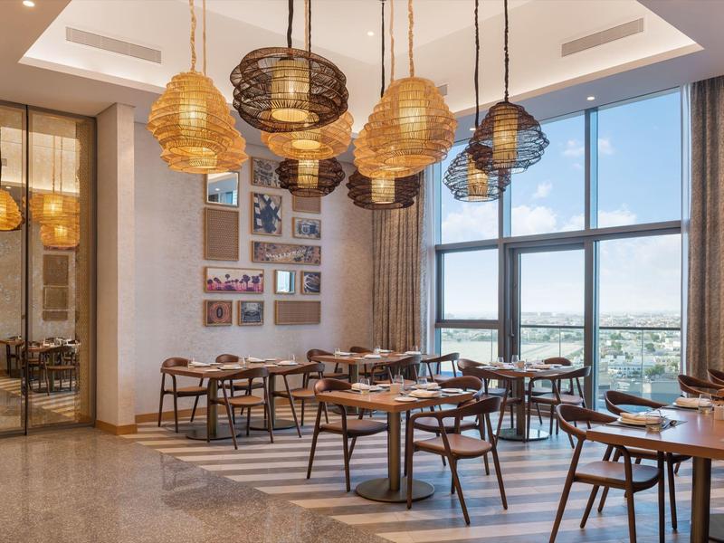 Modern, bright dining room with wooden furniture and large windows with a view.