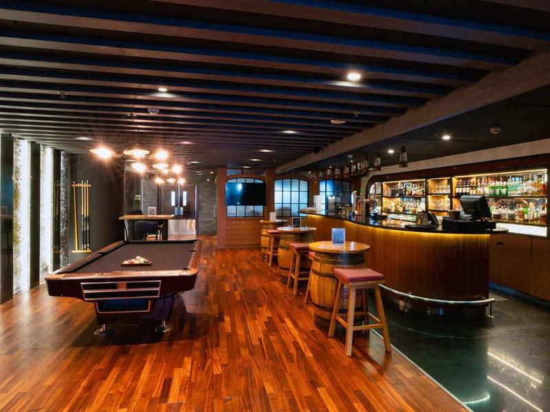 Moderne bar met stijlvolle houten vloer, biljarttafel en gezellige zitplaatsen.