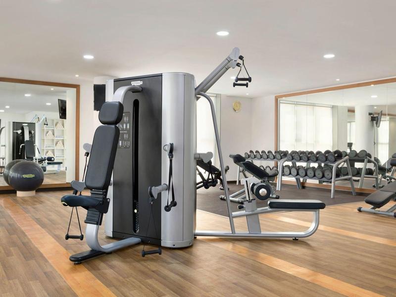 Moderne sportschool met krachtmachines en halters in een hotel.
