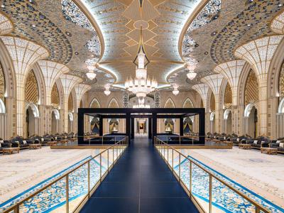 Prächtiger, reich verzierter Innenraum mit breitem Gang und hohen Kronleuchtern.