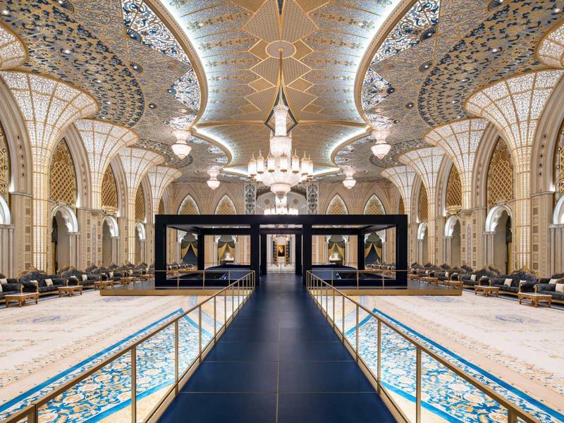 Prächtige Moschee mit hohen Bögen, kunstvollen Verzierungen und einem großen Kronleuchter.