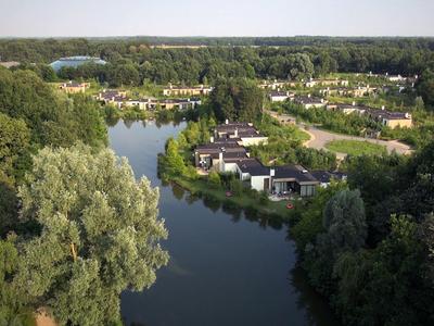 Krajina s řekou obklopenou domy a bohatou zelení v rekreační oblasti.