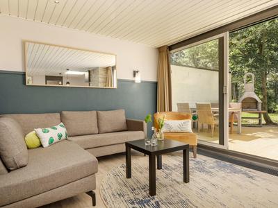 Pohodlný obývací pokoj s velkými skleněnými posuvnými dveřmi do zahrady a na terasu.