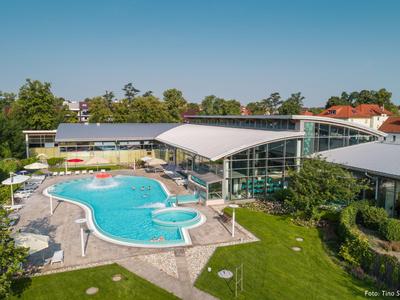 Moderner Hotelkomplex mit großem Außenpool und umliegendem Grün.