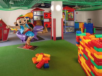 Salle de jeux colorée pour enfants avec de grands blocs de construction et une figure enfantine joyeuse.
