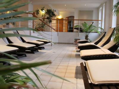 Innenbereich eines Wellnessbereichs mit Liegestühlen und Pflanzen in einem Hotel