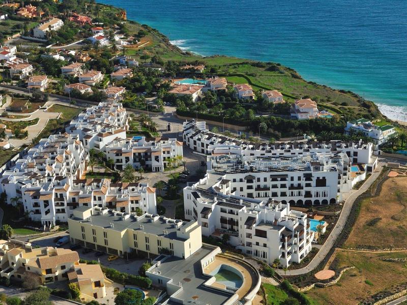 Aerial view of a coastal town with white buildings and a nearby beach.