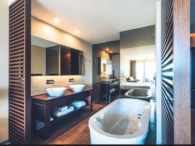 Modernes Badezimmer mit freistehender Badewanne, Doppelwaschbecken und Holzdetails.