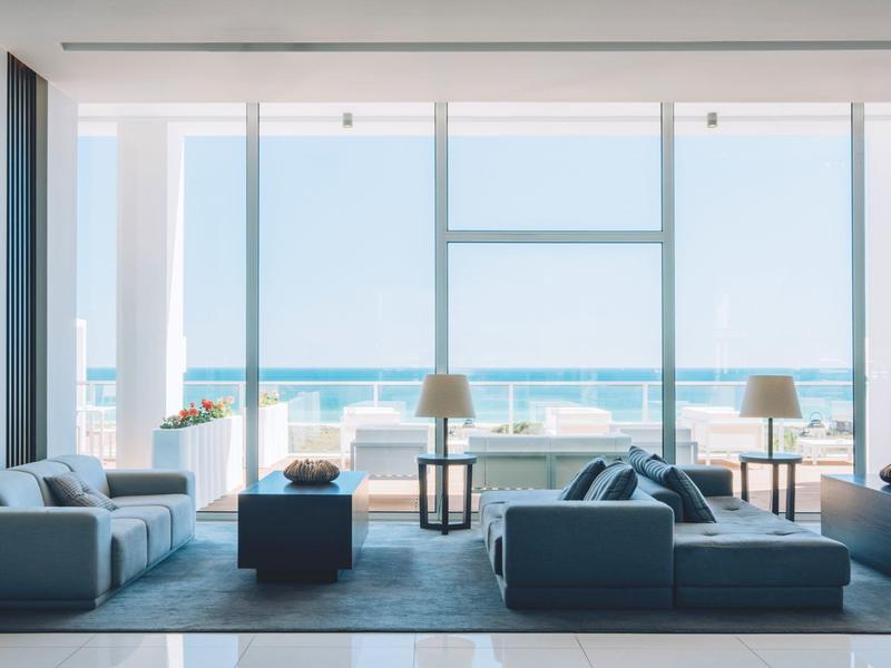 Nowoczesny salon z dużymi oknami i widokiem na morze w hotelu.