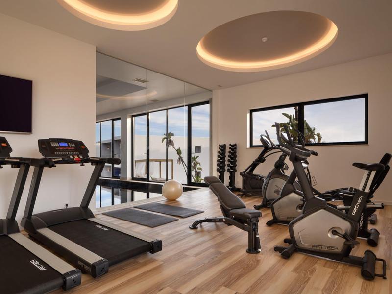 Moderne sportschool met loopbanden, hometrainers en grote ramen met uitzicht.