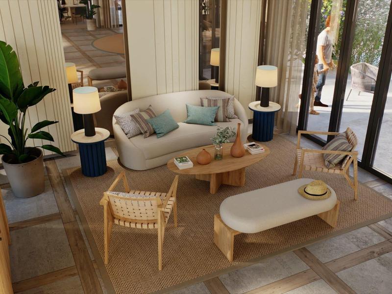 Lichte en moderne hotellounge met bank, fauteuils en grote ramen naar de buitenruimte.