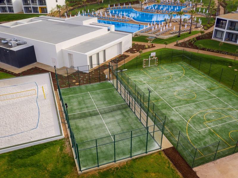 Uitzicht op een resort met zwembaden, tennisbaan en volleybalveld