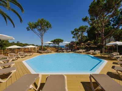 Espace piscine avec chaises longues et parasols dans un hôtel tropical