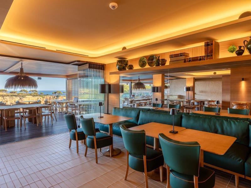 Restaurant moderne avec des zones de sièges confortables et une terrasse avec vue sur la mer.