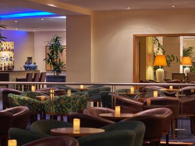 Pohodlný hotelový salón s pohodlnými křesly a jemným světlem svíček.