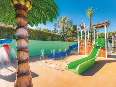 Bunter Wasserspielplatz mit grüner Rutsche und tropischem Thema im Hotelgarten.