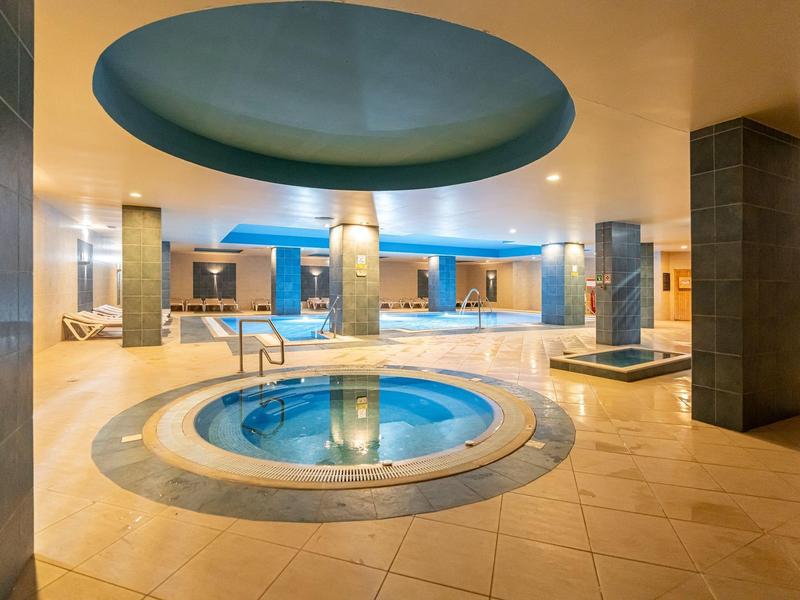 Overdekte hotel spa met een cirkelvormig zwembad en warme sfeerverlichting