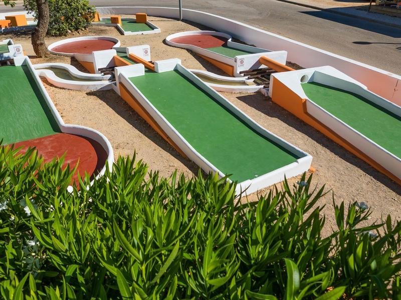 Meerdere buitenminigolfbanen met groene oppervlakken en oranje hindernissen