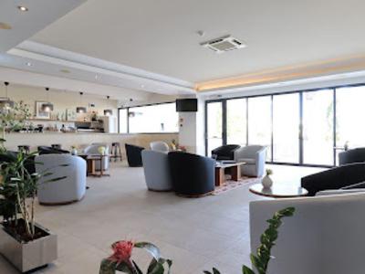 Nowoczesny salon hotelowy z miejscami do siedzenia, dużymi oknami i jasną atmosferą.