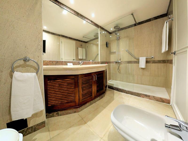 Nowoczesna łazienka z prysznicem, wanną, umywalką i dużymi lustrami.